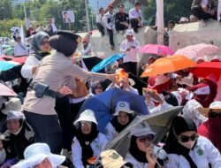 Polisi Bagikan Air Mineral dan Roti kepada Massa Aksi Damai Guru di Silang Selatan Monas